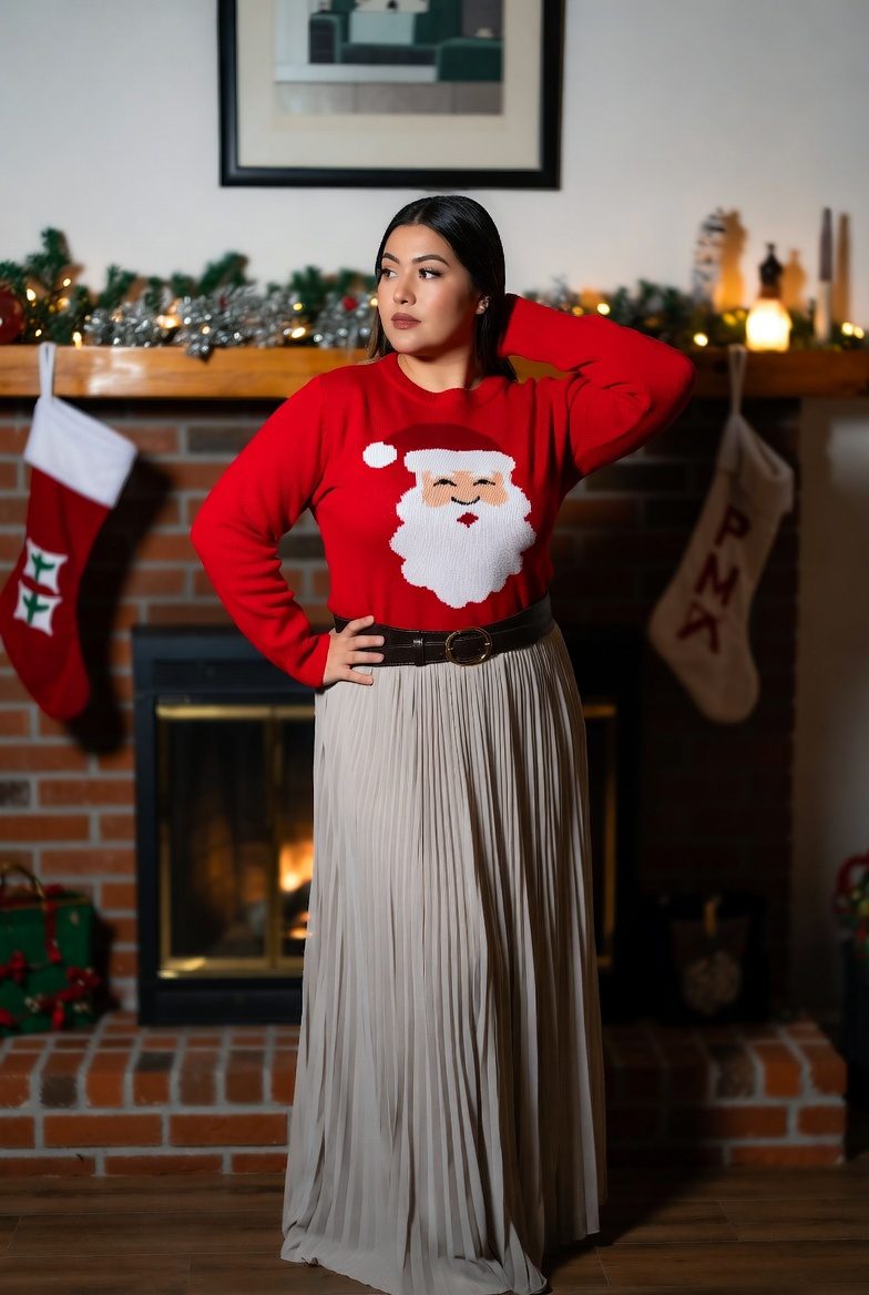 Medium-sized Asian woman wearing a Santa graphic sweater with a pleated maxi skirt, whimsical festive holiday outfit.