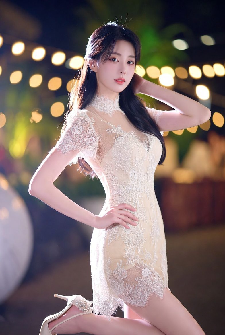 Korean woman wearing an elegant cream lace dress in warm evening lighting.
