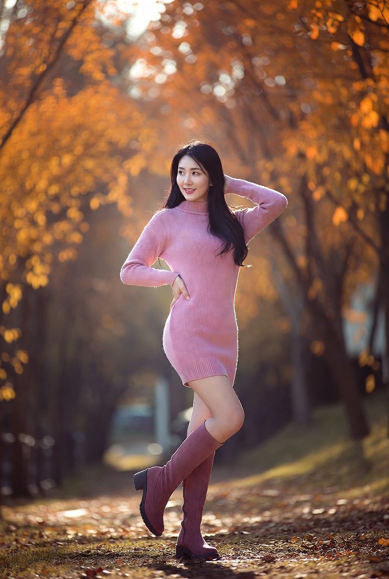 Korean woman in a pink sweater dress paired with knee-high boots, styled in a cozy autumn look.