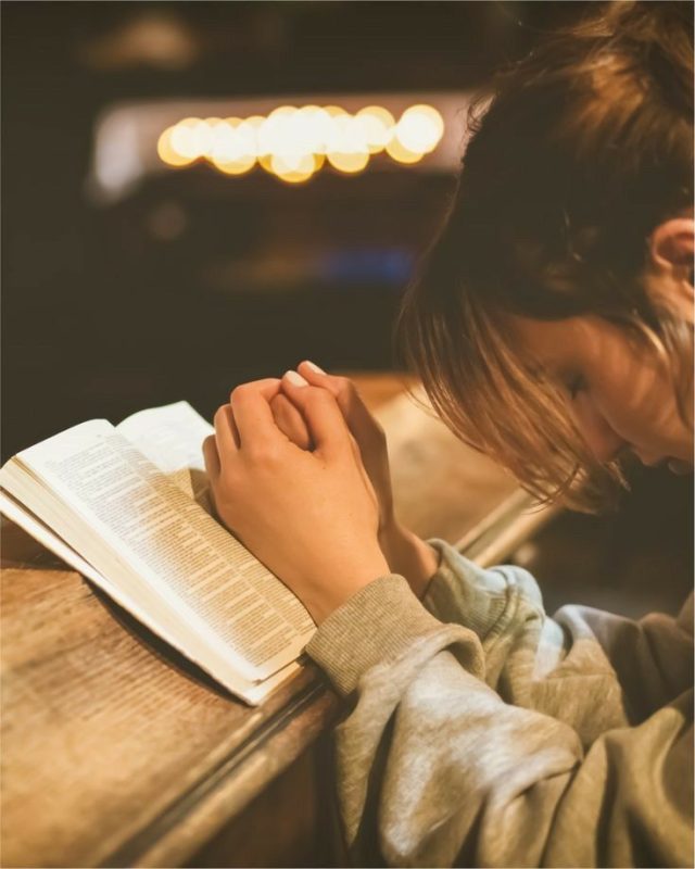 Person praying with Bible - finding peace in Psalms